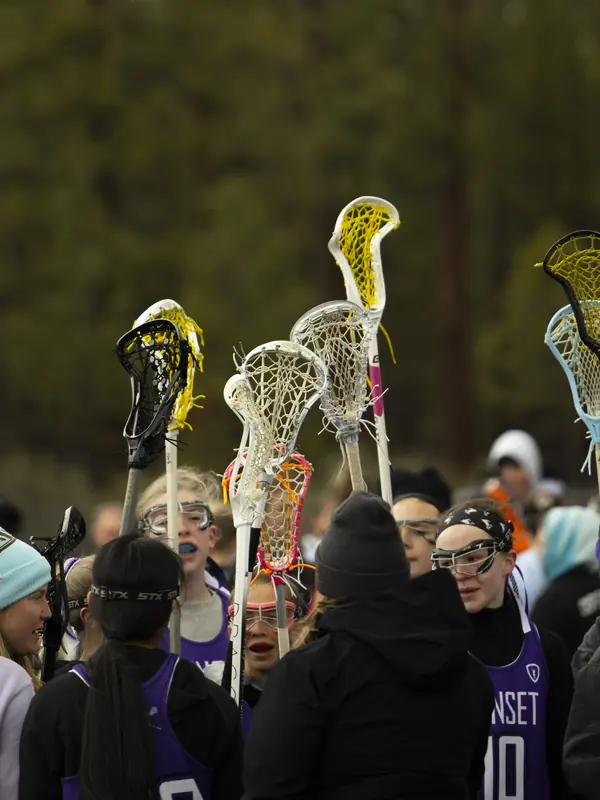 A team huddles with sticks raised