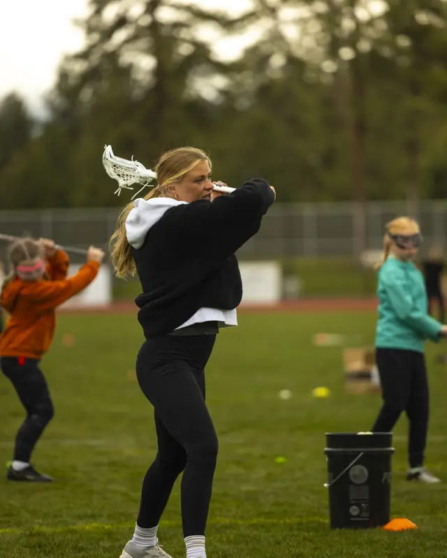 A coach demonstrates a shot for the girls session