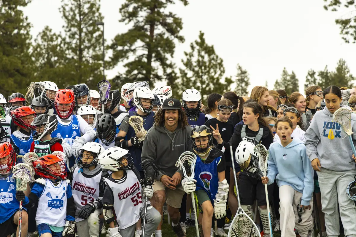 A pro coach surrounded by young players at the clinic
