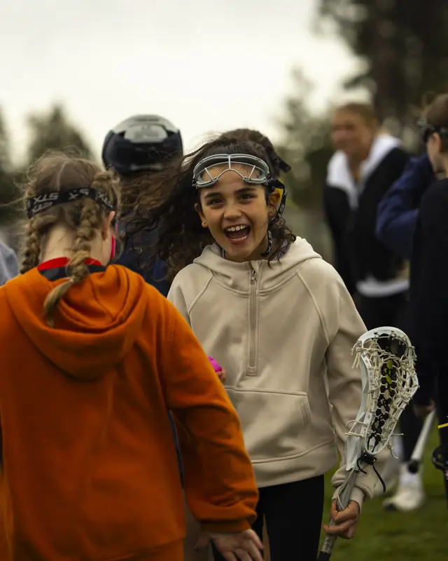 A young player laughs with friends between drills