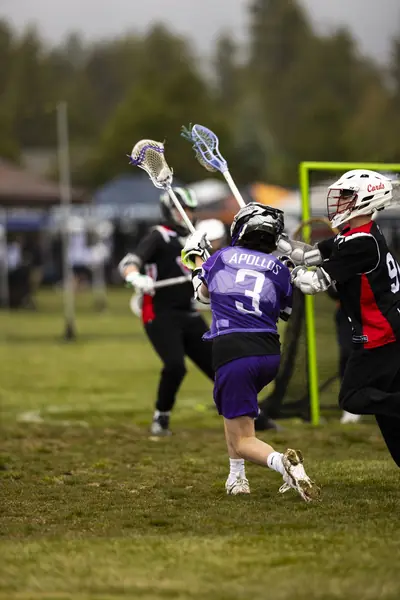 A boys player drives to the goal through two defenders