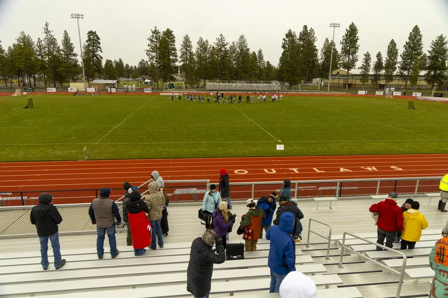 Spectators in the stands above the Sisters High School stadium field
